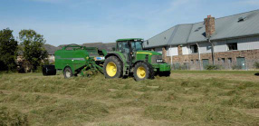 Photo: Harvester making hay on open meadow